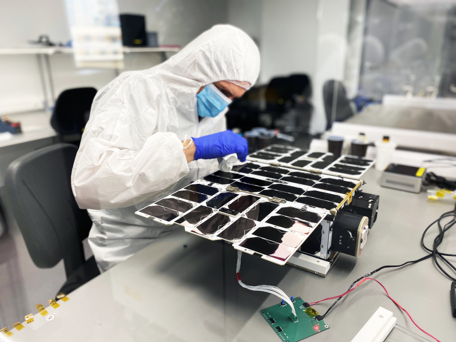 satsearch nanoavionics a satellite engineer works on a small satellite system